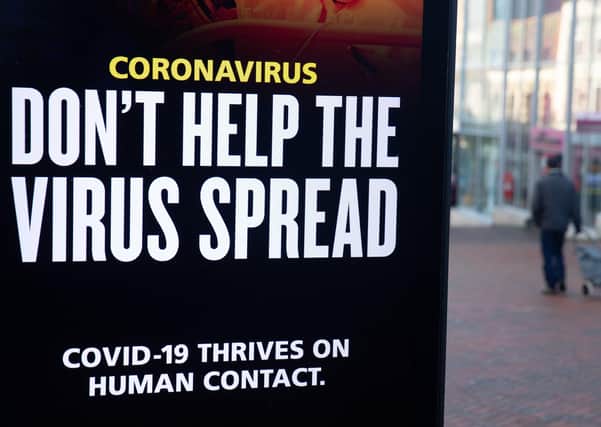 A person passes a 'Don't help the virus spread' government coronavirus sign on Commercial road in Bournemouth, during England's third national lockdown to curb the spread of coronavirus. Picture date: Friday January 22, 2021.