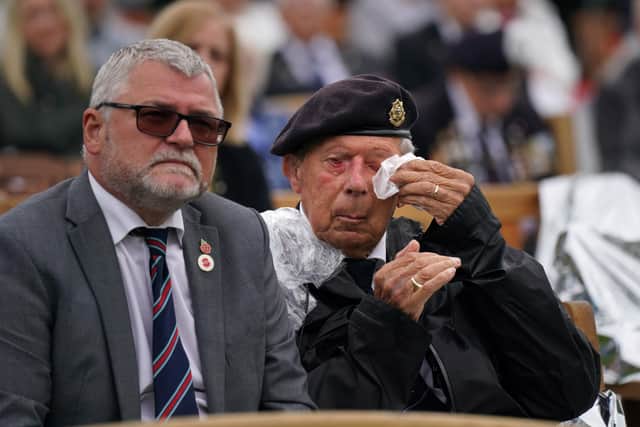 A veteran wipes his eyes while watching the official opening of the British Normandy Memorial in France via a live feed