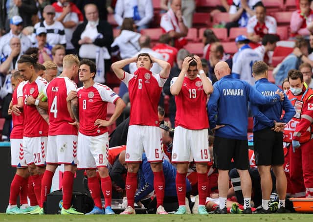 Denmark's players react as paramedics attend to Denmark's midfielder Christian Eriksen after he collapsed on the pitch during the UEFA EURO 2020 Group B football match between Denmark and Finland at the Parken Stadium in Copenhagen on June 12, 2021. (Photo by FRIEDEMANN VOGEL/POOL/AFP via Getty Images)