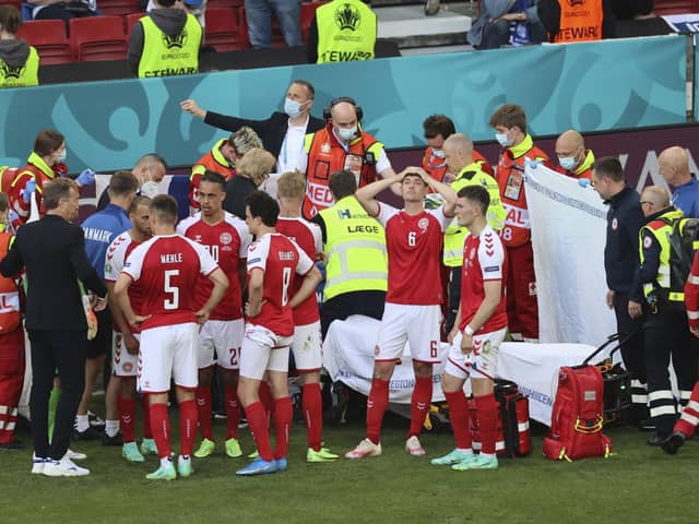 Denmark's players react as their team-mate Christian Eriksen receives treatment during the Euro 2020 match with Finland in Copenhagen on Saturday. Pic by PA.