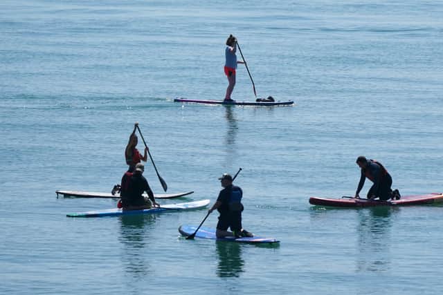 Paddleboarders take to the sea off of Hastings beach in East Sussex. Picture date: Sunday June 13, 2021