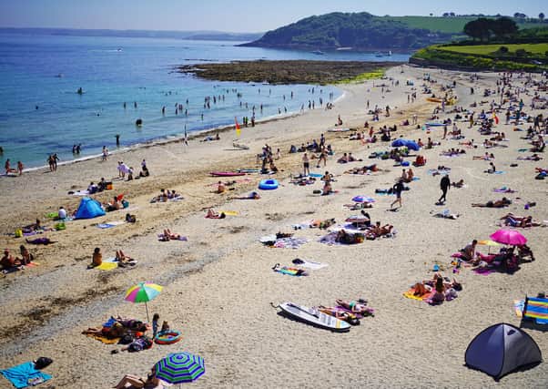 People enjoy the sunshine on Gyllyngvase Beach near Falmouth in Cornwall on Sunday. Southern England enjoyed hot weather, as did the north coast of Northern Ireland, where it hit 28.3C on the Giant's Causeway (78F)  Photo/PA Wire