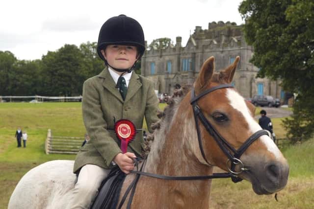 Seven-year-old Toby McAlpine from Augher on "Barley Sugar" winner of the Open First Ridden Class at Enniskillen Horse and Pony Show.