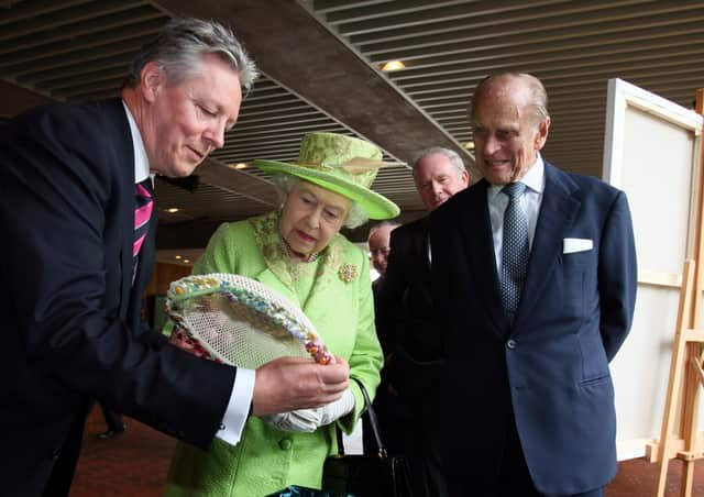Peter Robinson as first minister shows the Queen and Prince Philip a gift at the Lyric Theatre in Belfast, with the deputy first minister Martin McGuinness looking on, in June 2012, on the Queen’s jubilee visit