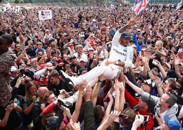 NORTHAMPTON, ENGLAND - JULY 10:  Lewis Hamilton of Great Britain and Mercedes GP crowd surfs with the fans to celebrate his win during the Formula One Grand Prix of Great Britain at Silverstone on July 10, 2016 in Northampton, England.  (Photo by Clive Mason/Getty Images)