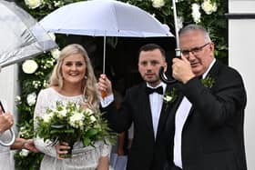 Laura and Philip Kennedy on their wedding day at Banbridge Road Presbyterian Church in Dromore today with Philip's father Danny Kennedy. Pic by Colm Lenaghan/Pacemaker