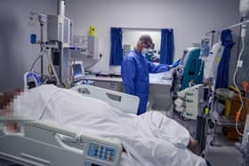 A doctor treats a Covid-19 patient in an ICU.
