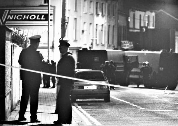 RUC men silhouetted by a streetlight in Londonderry in 1994, as they survey the scene of a fatal IRA mortar attack;  the force was accorded the George Cross for its work in the face of decades of deadly violence