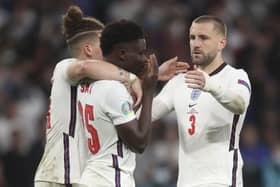 England’s Kalvin Phillips (left) and Luke Shaw comfort Bukayo Saka following defeat to Italy in the EURO 2020 final on a penalty shootout. Pic by PA.