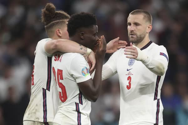 England’s Kalvin Phillips (left) and Luke Shaw comfort Bukayo Saka following defeat to Italy in the EURO 2020 final on a penalty shootout. Pic by PA.