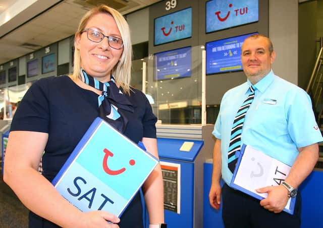 TUI's Sarah Murphy and Liam Mcllwrath  assisting customers checking in for TUI's first flight of 2021, departing from Belfast International Airport to Majorca.