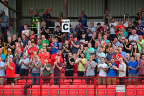 Larne fans salute the players after their win
