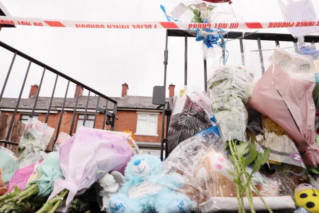 Flowers and cuddly toys are left on the footpath outside the house where baby Liam O'Keefe was killed.