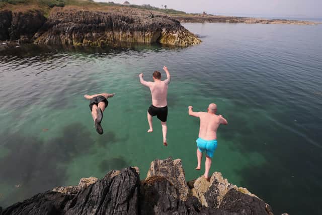 Divers cool off by plunging into the sea at Orlock, Co Down in the middle of last month’s record-breaking heatwave