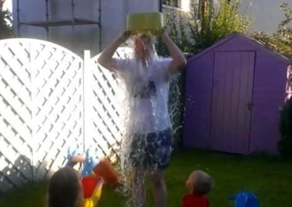 Graeme Cousins takes on the ice bucket challenge in 2014 with the help of his children Lucy and Ben