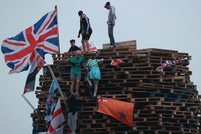 Flags and banners are hung on a large bonfire being built to mark the Catholic Feast of the Assumption in the Galliagh area of Londonderry