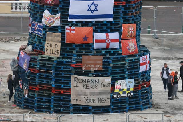 Flags and banners are hung on a large bonfire being built to mark the Feast of the Assumption in the Bogside area of Londonderry