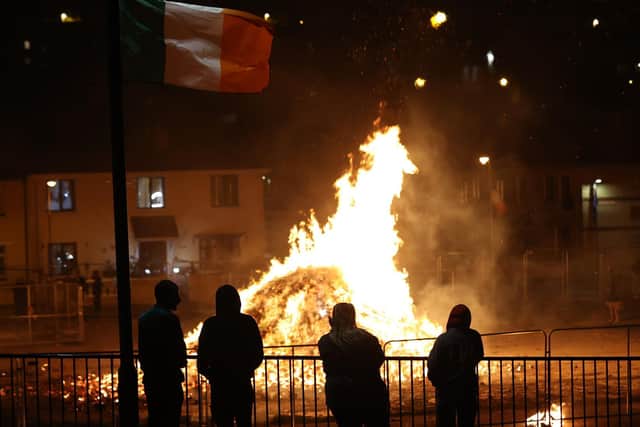 A large bonfire, lit to mark the Feast of the Assumption, burns to its embers in the Bogside area of Londonderry