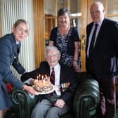 William Nesbitt is presented with his 100th birthday cake from RAF Wing Commander Jacqs Rankin as his daughter Johneen Dempsey and son in law Adrian Dempsey look on