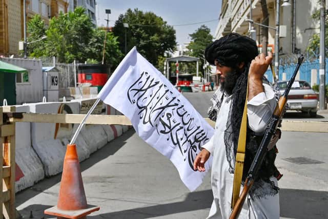 A Taliban fighter patrols along a street in Kabul on August 17, 2021, as the Taliban moved quickly to restart the Afghan capital following their stunning takeover of Kabul and told government staff to return to work. (Photo by WAKIL KOHSAR/AFP via Getty Images)
