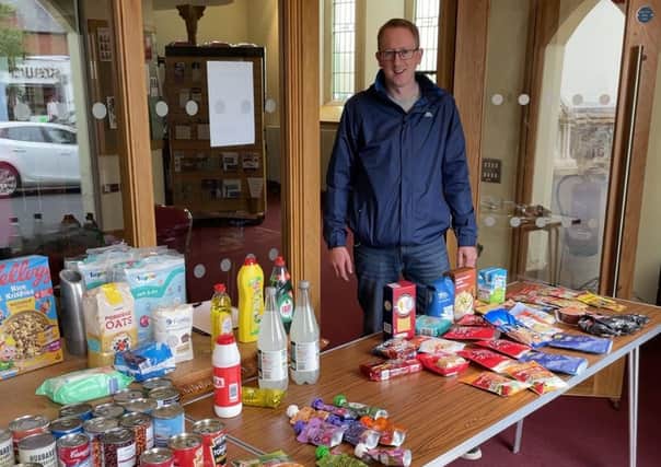Rev Jimmy Warburton at the 'manna table' of donated items in Holywood