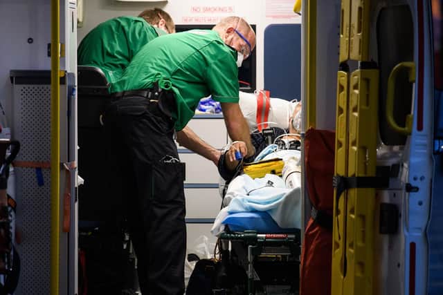 Paramedics assist a patient as they arrive at the Royal London hospital