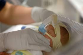 An infant is fitted with a ventilator mask in the neonatal intensive care unit at the Regional Medical Center in Memphis, Tenn. (AP Photo/Greg Campbell)