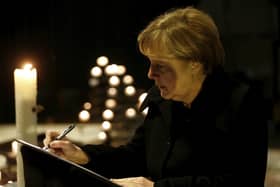 Angela Merkel in 2016 signs the condolence book at the Memorial Church in Berlin for the truck terror attack in the city . The German chancellor has said: ‘I believe in God and religion is my constant companion. We Christians should not fear standing up for our beliefs’ (AP)