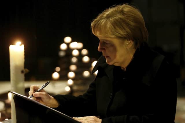 Angela Merkel in 2016 signs the condolence book at the Memorial Church in Berlin for the truck terror attack in the city . The German chancellor has said: ‘I believe in God and religion is my constant companion. We Christians should not fear standing up for our beliefs’ (AP)