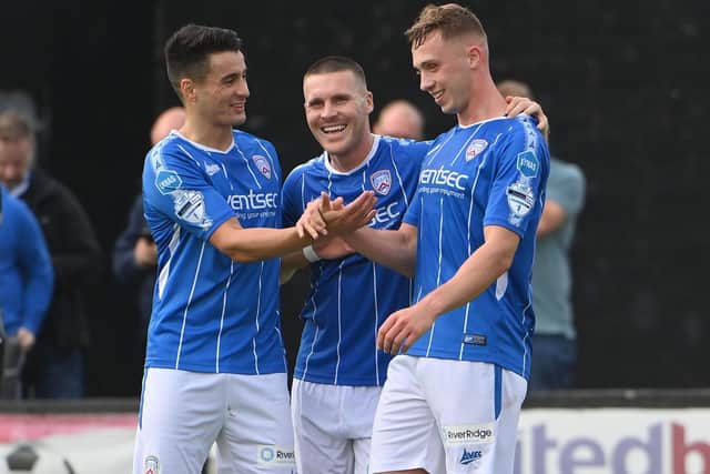 Matthew Shevlin celebrates his brace against Carrick Rangers with Aaron Traynor and Josh Carson