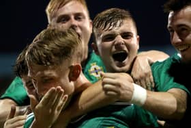 Northern Ireland’s Ethan Galbraith is mobbed by his teammates after firing in from the spot