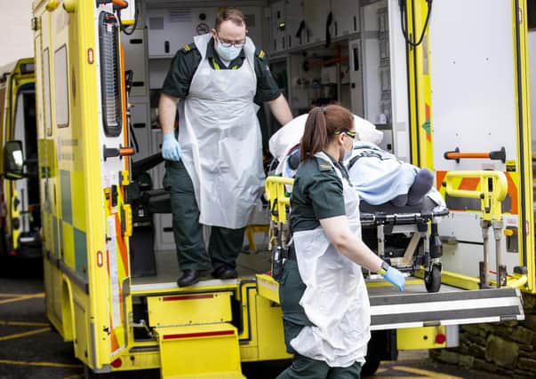 Student EMT Ruth Corscadden (centre) and Paramedic Daniel McCollam with a patient at Causeway Hospital during their shift for the Northern Ireland Ambulance Service covering the Northern Trust's Hospitals. Picture date: Monday January 18, 2021.
