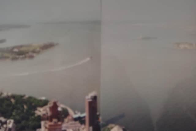 Two pictures taken by  Louise Traynor (nee Woods), placed side by side, from her office in the World Trade Center complex in New York in 2001. She worked on the 101st floor of the south tower. The pics show the southerly view, with the Statue of Liberty island to right of the image