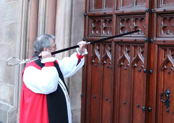 Archbishop John McDowell knocks on the door of St Patrick’s Cathedral, Armagh, with his crozier before the Service of Enthronement