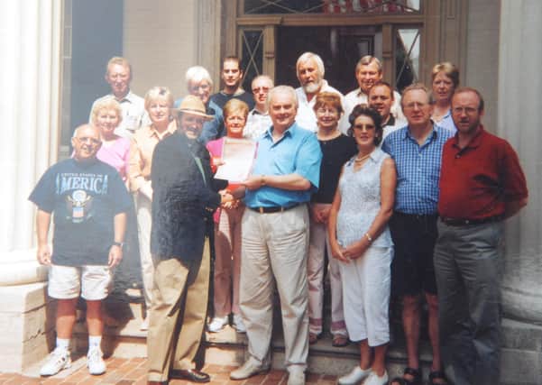 The Ulster Scots group in Knoxville pictured on September 11 2001. In the middle in a blue shirt holding the document is the late Lord Laird, his wife Carol to the right of him. Above them, the bearded man is George Holmes, who was culture director at Ulster Scots Agency. Billy Kennedy is partly obscured behind the man in the hat, his wife Sally is in white trousers immediately to the left of the man with hat. Sally died on Thursday