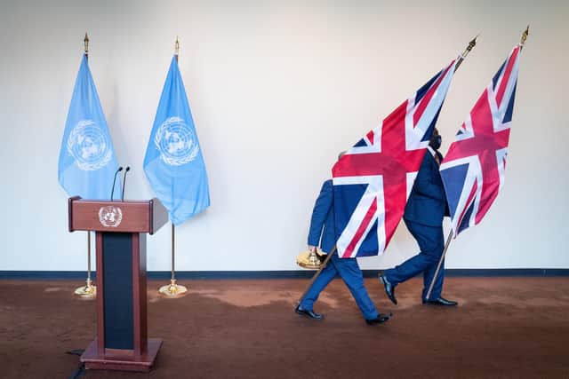 Officials remove Union Flags from the stage after a Boris Johnson press conference at the United Nations in New York on Monday