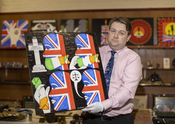 Auctioneer Carl Bennett holding art by Michael Stone, one of the lots for sale at Bloomfield Auctions in east Belfast next week. Picture date: Monday September 20, 2021.