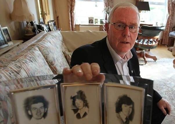Eugene Reavey with photographs of his murdered brothers