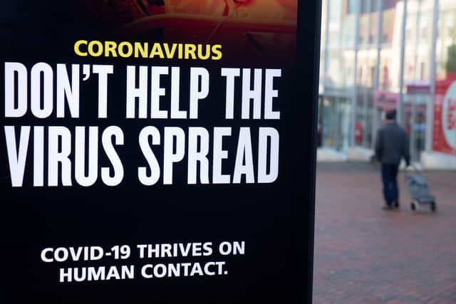 A person passes a 'Don't help the virus spread' government coronavirus sign on Commercial road in Bournemouth, during England's third national lockdown to curb the spread of coronavirus. Picture date: Friday January 22, 2021.