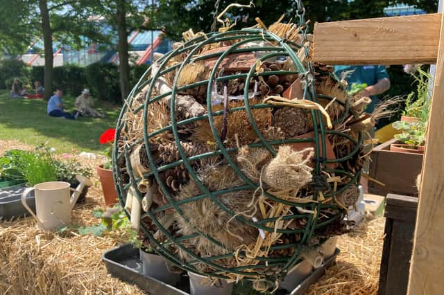 Two hanging basket frames joined together to make a circular bug hotel.