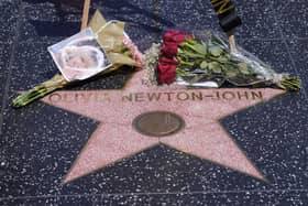 Flowers adorn Olivia Newton-John's Hollywood Walk of Fame star in Los Angeles, Monday, Aug. 8, 2022. Newton-John, the Grammy-winning superstar who reigned on pop, country, adult contemporary and dance charts with such hits as "Physical" and "You're the One That I Want" has died. She was 73. (AP Photo/Damian Dovarganes)