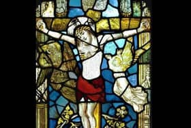 A stained glass image of Christ on the cross