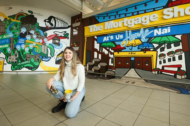 Danni Simpson at her new mural at Belfast City Airport