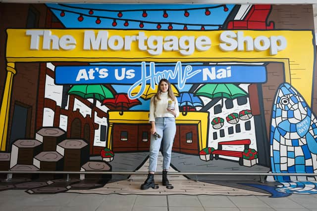 Danni Simpson at her new mural at Belfast City Airport