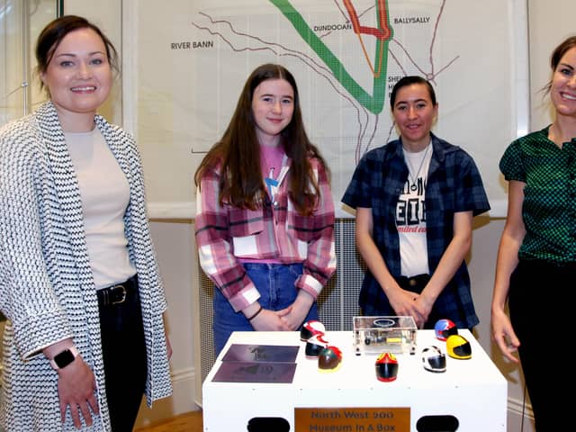 Rachel Archibald (Museums Officer) with participants and facilitators, admiring the 3D motorbike helmets made as part of the Reimagine, Remake, Replay programme in Ballymoney Museum