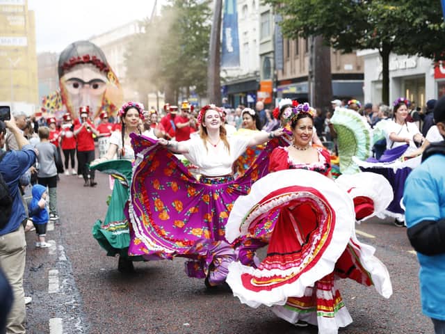 People line the streets as the Mela Carnival parades through Belfast City Centre on Saturday. Photo: Peter Morrison/PA Wire