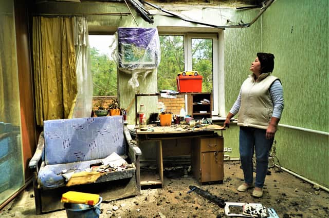Ukraine resident Ivanna Vasylykha standing in the ruins of her shelled home in Kharkiv at the end of May this year