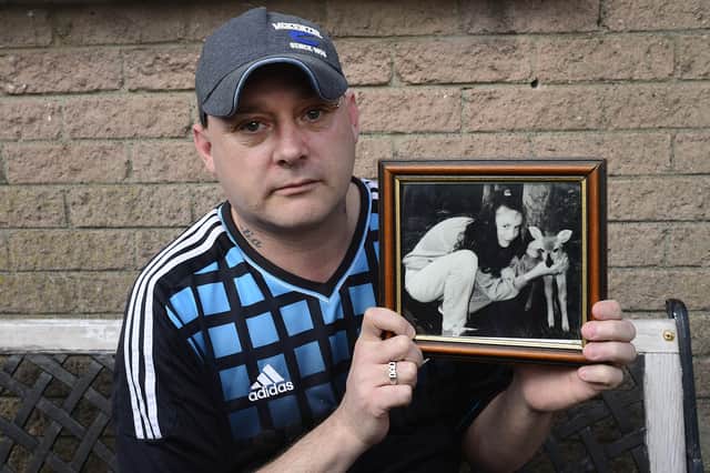 Gary Murray pictured today holding a photo of his 13-year-old sister Leanne. Picture: Arthur Allison/Pacemaker Press