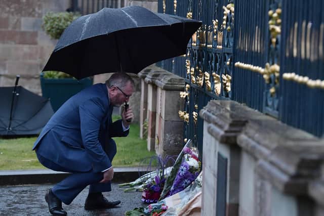 Ulster Unionist party leader Doug Beattie looks at flowers lain by members of the public at Hillsborough castle. (Photo by Charles McQuillan/Getty Images)