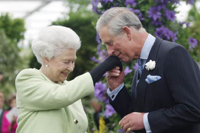 Queen Elizabeth II presents Prince Charles, Prince of Wales with the Royal Horticultural Society's Victoria Medal of Honour during a visit to the Chelsea Flower Show on May 18, 2009
